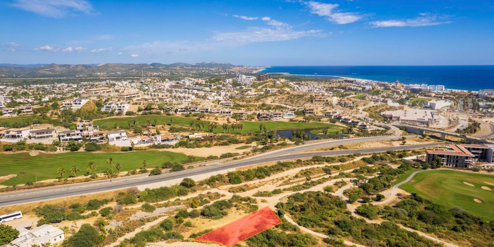 Vista aerea de Club Campestre San Jose del Cabo, con el campo de golf en la ladera y el Mar de Cortes al fondo
